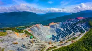Illustration of the Grasberg Mine nestled in the mountains of Papua, Indonesia, highlighting its vast infrastructure and environmental setting.