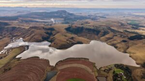 A stunning aerial shot showcasing the diverse terrain and serene lake of South Africa.