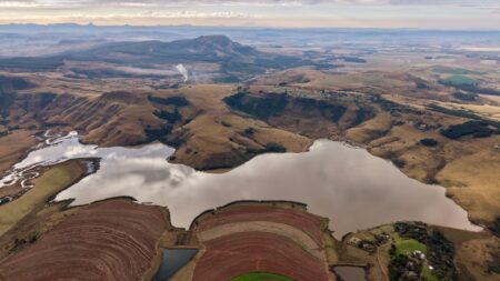 A stunning aerial shot showcasing the diverse terrain and serene lake of South Africa.